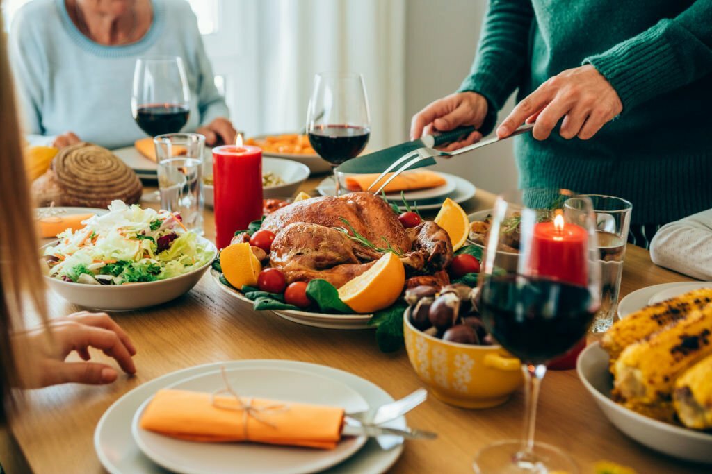 Close-up shot of a male hands cutting roasted turkey on Christmas or Thanksgiving Day.